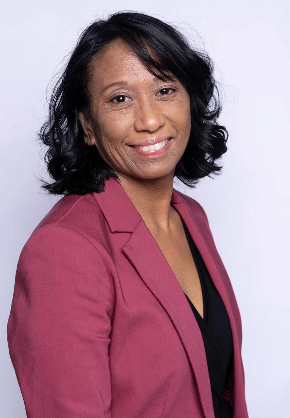 Portrait of Donna Laggui Crombie wearing a magenta blazer