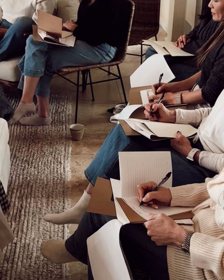 Women writing together during a reflective session