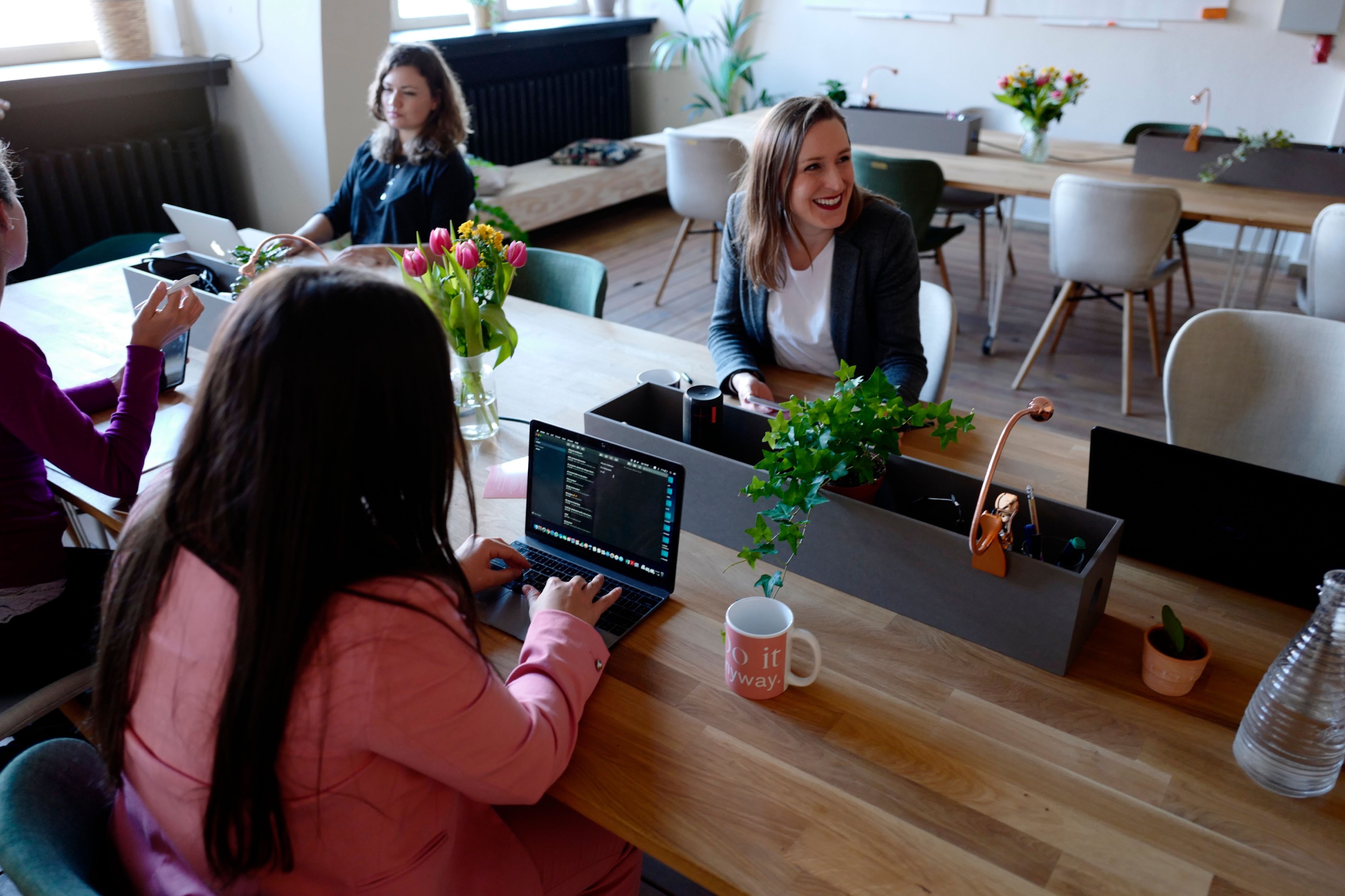 Women collaborating around a table in a bright shared workspace